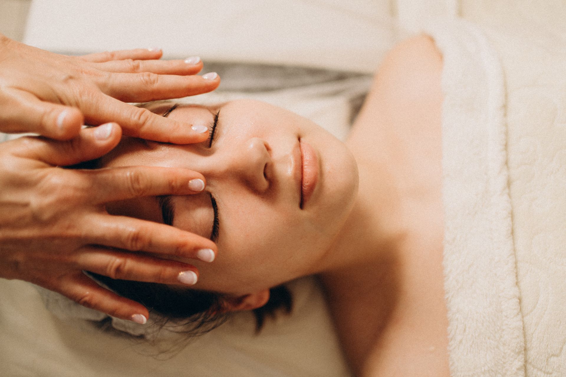 Una donna si sta sottoponendo a un massaggio facciale in una spa.