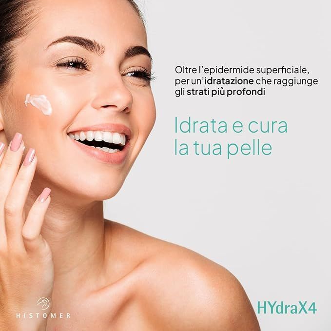 Una donna sorride mentre si applica una crema sul viso.