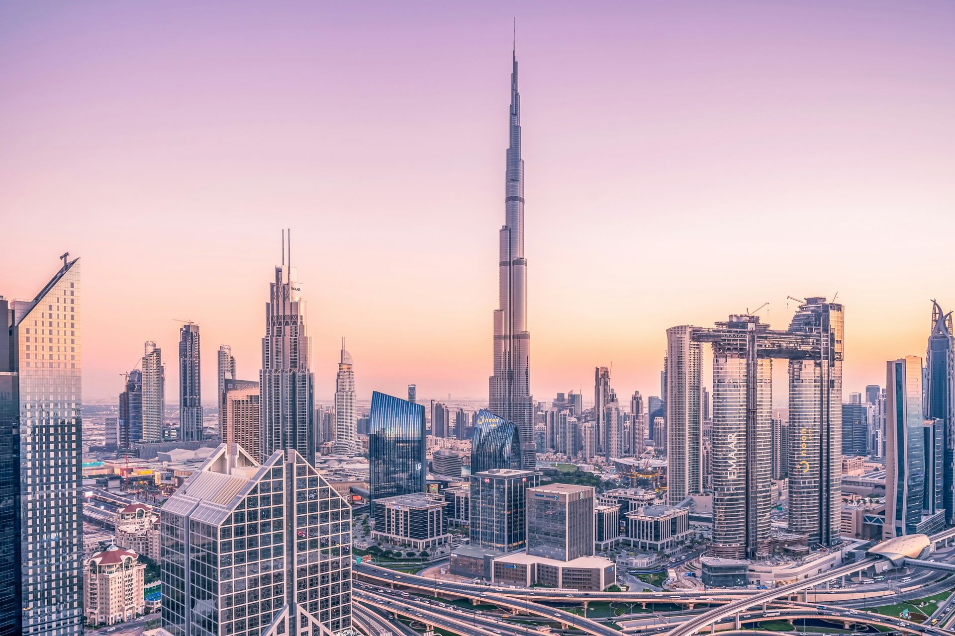 An aerial view of the skyline of dubai at sunset.