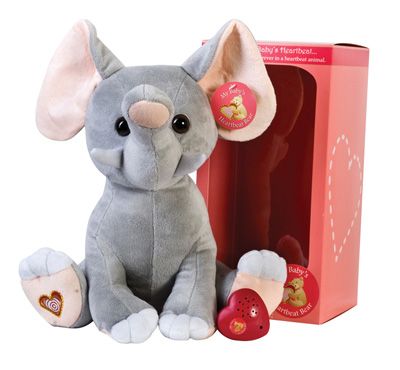 A stuffed elephant is sitting next to a box that says baby 's heartbeat