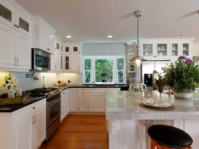 A kitchen with white cabinets and stainless steel appliances