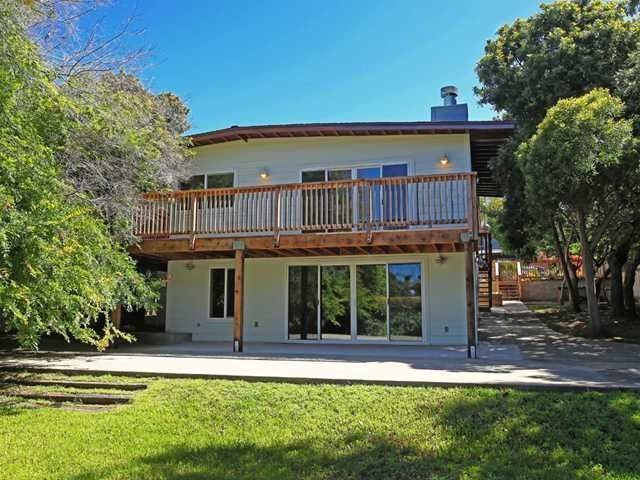 The back of a house in Encinitas, CA with a large deck and a lot of windows.