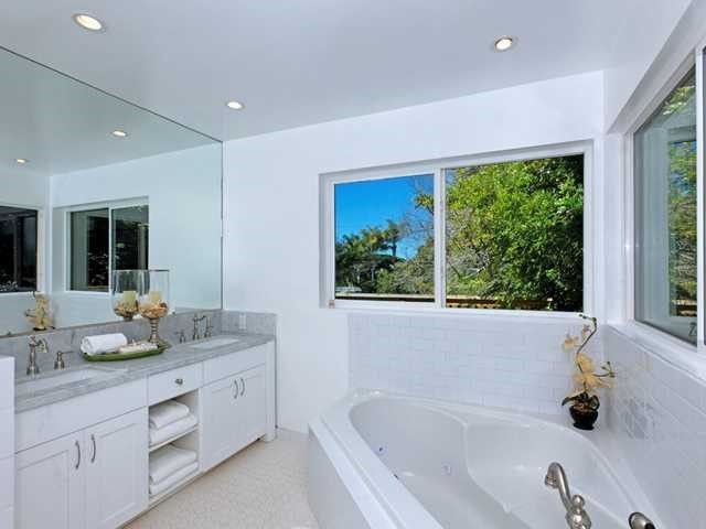 A bathroom with a tub and a large mirror