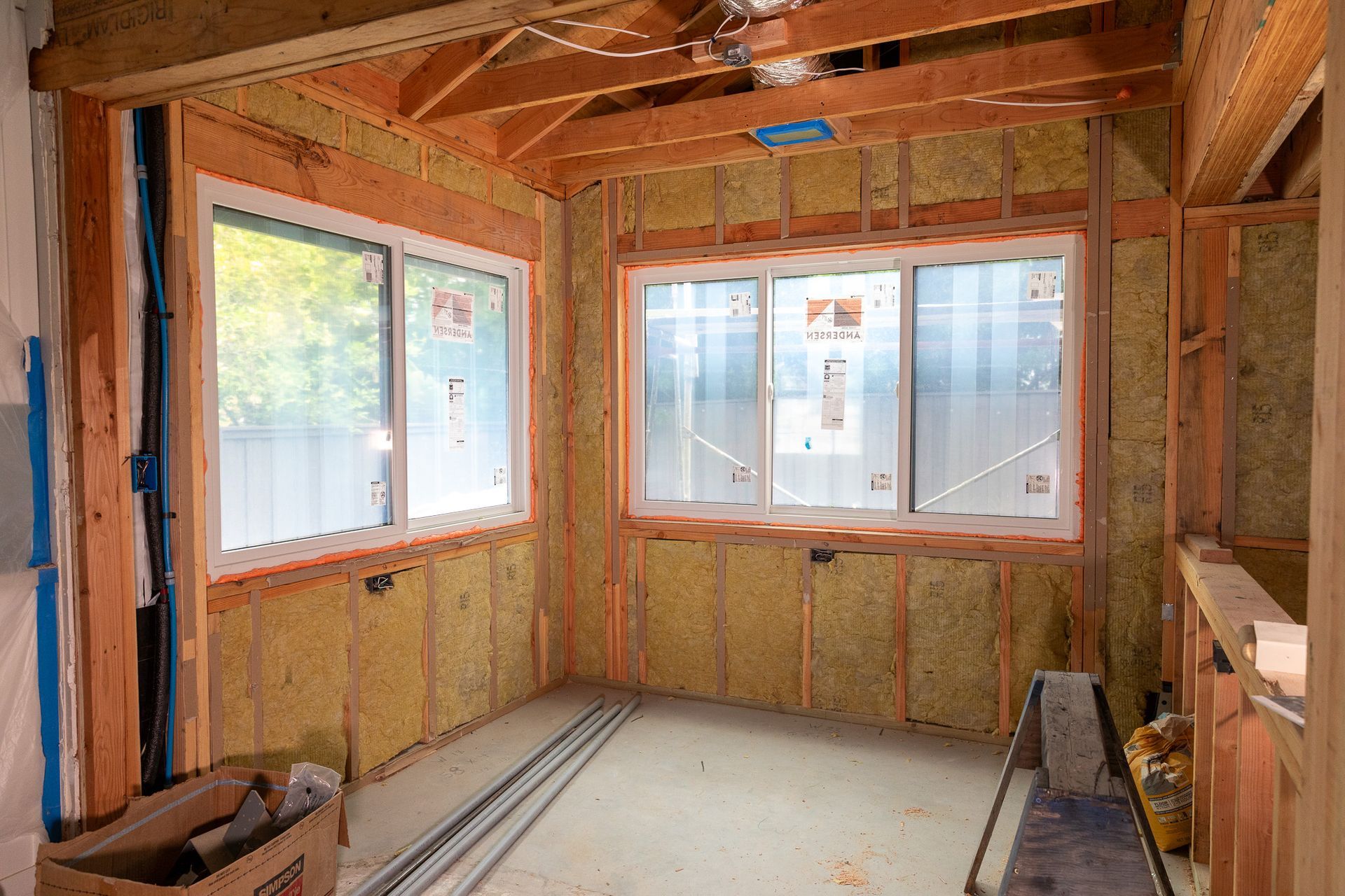 A room with a lot of windows and insulation on the walls.
