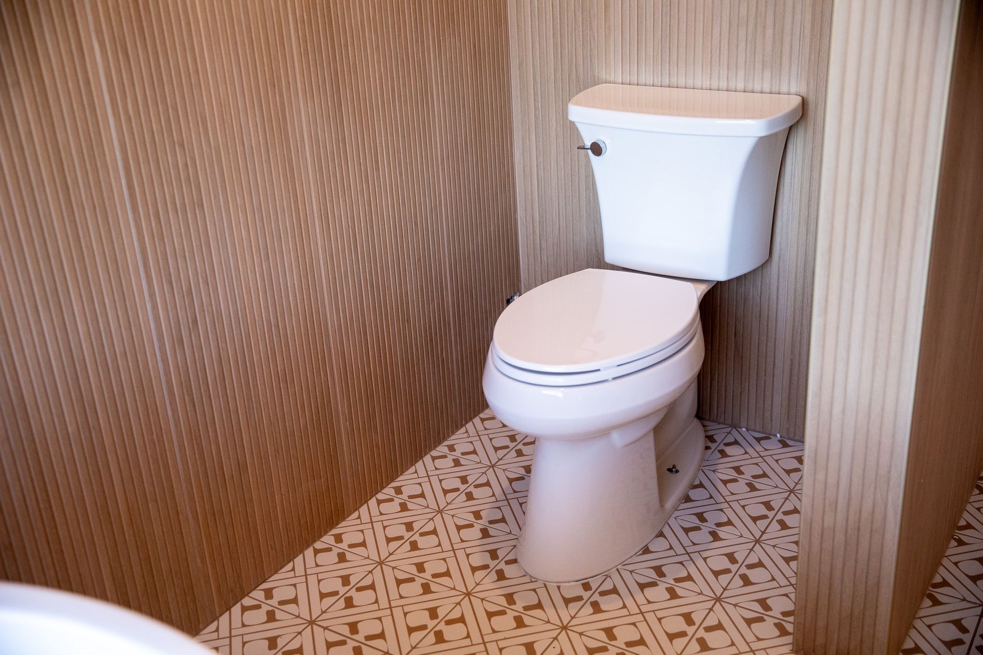A white toilet is sitting in a bathroom next to a sink.