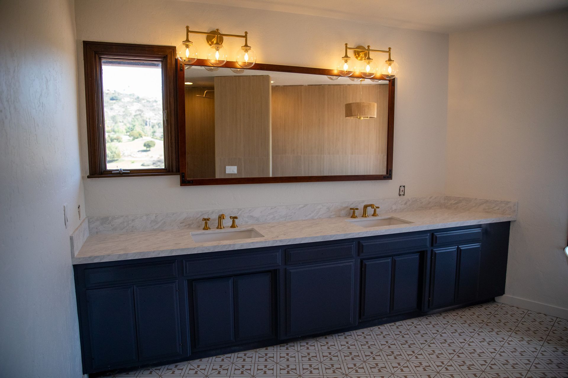 A bathroom with two sinks and a large mirror.
