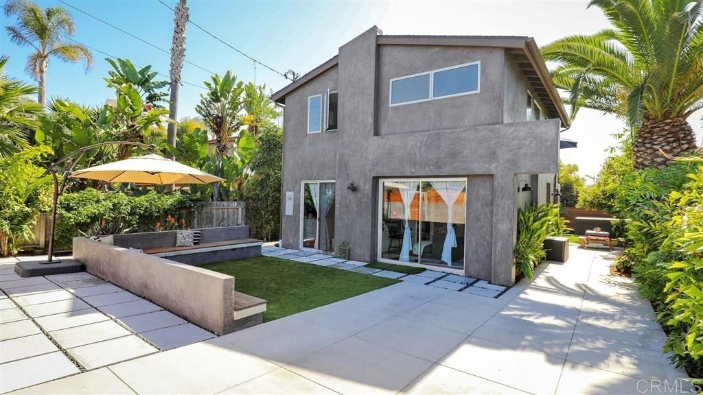 A large house with a lot of windows and palm trees