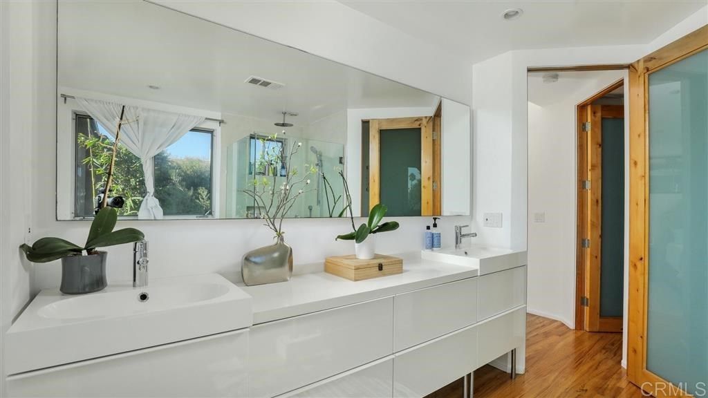 A bathroom with two sinks and a large mirror.