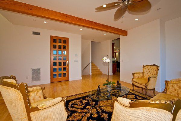 A living room with chairs and a ceiling fan