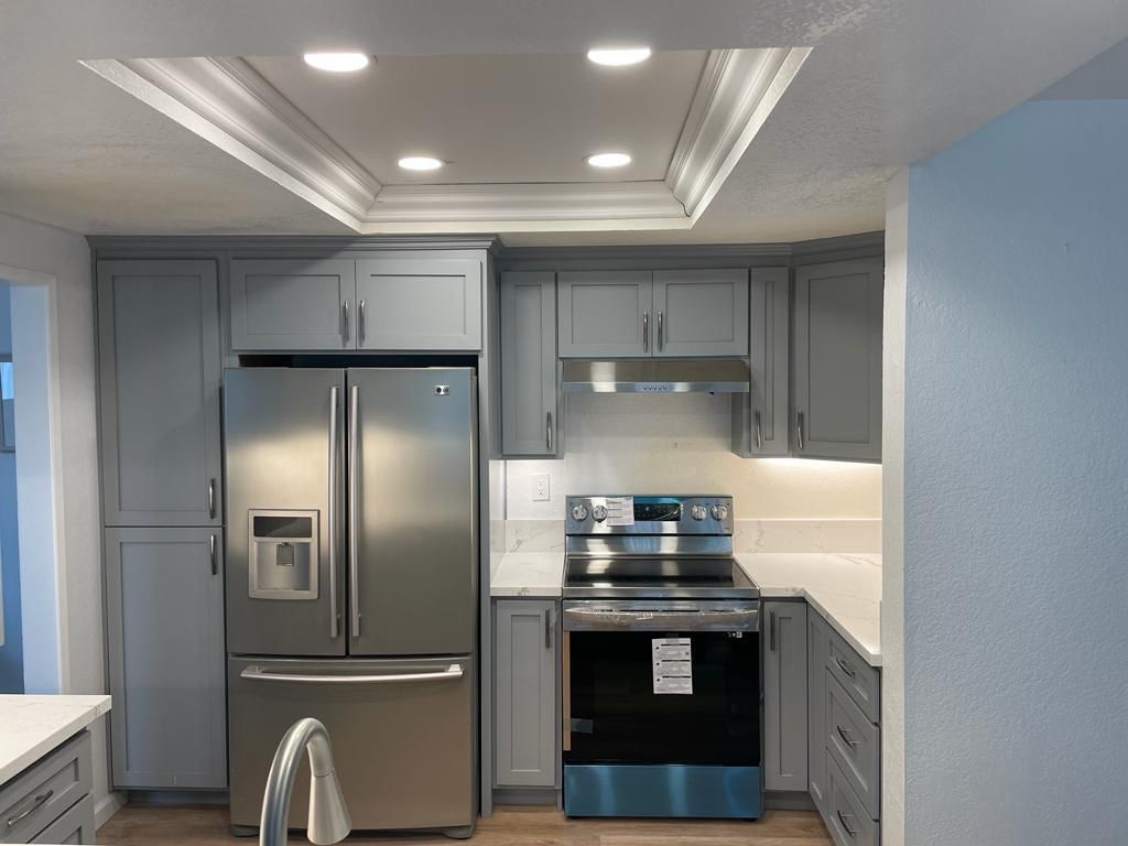 A kitchen with stainless steel appliances and gray cabinets