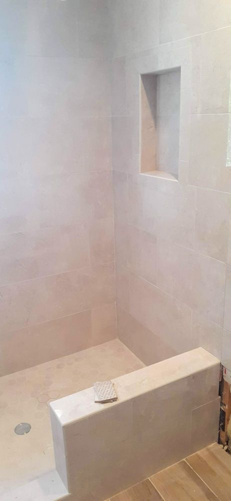 A bathroom with a walk in shower and a wooden floor.