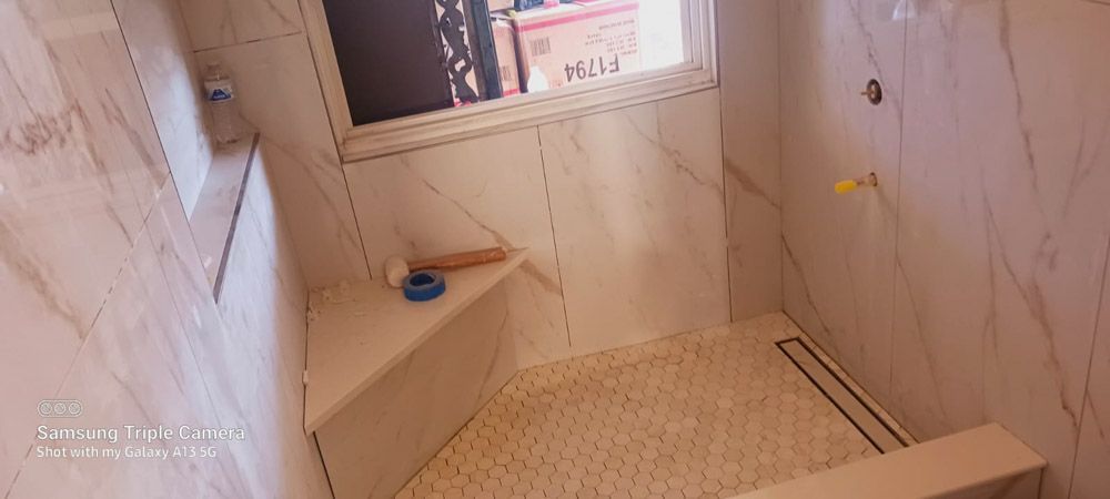 A bathroom with a walk in shower and a window.