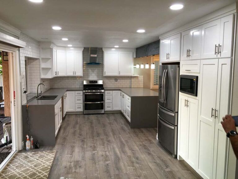 A kitchen with white cabinets and stainless steel appliances.