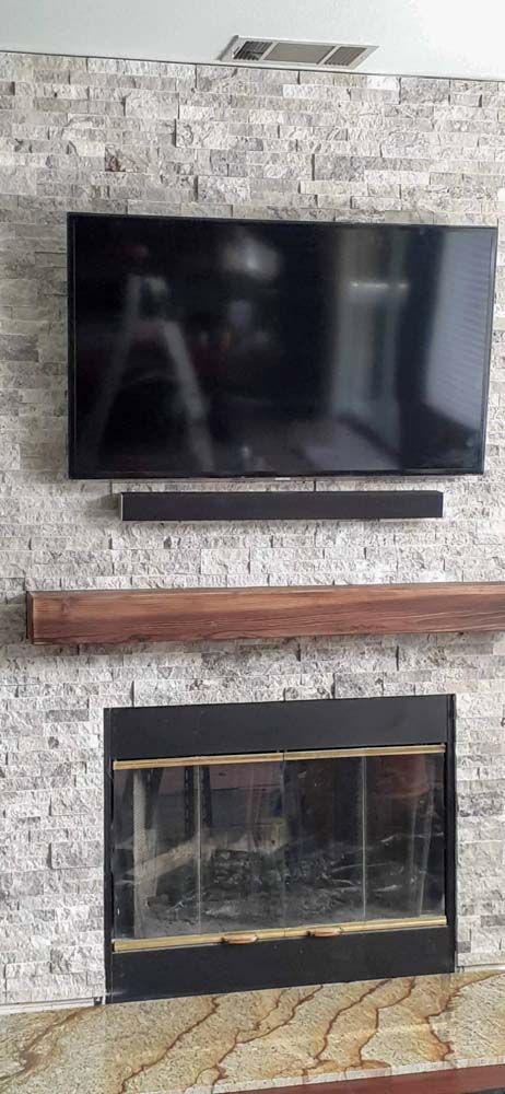 A living room with a fireplace and a flat screen tv mounted on the wall.