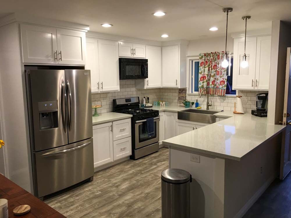 A kitchen with stainless steel appliances and white cabinets.