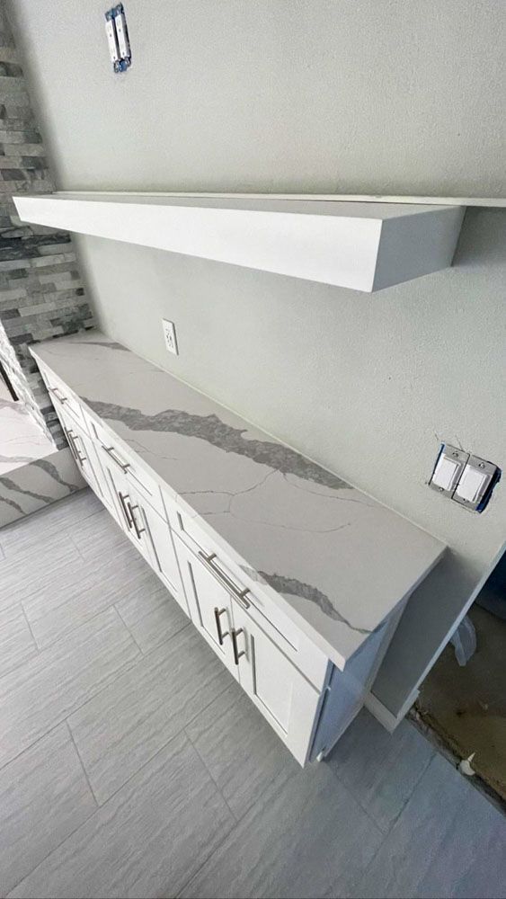 A kitchen with white cabinets and a white counter top.