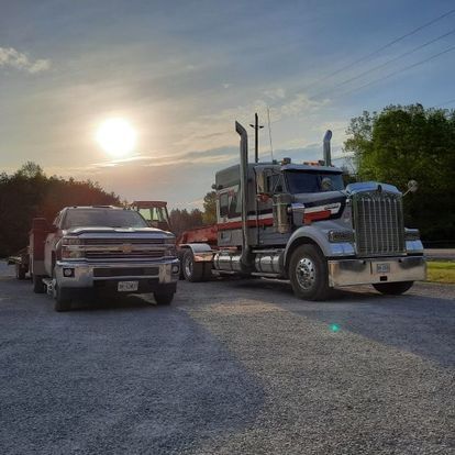 A dump truck is driving down a dirt road.