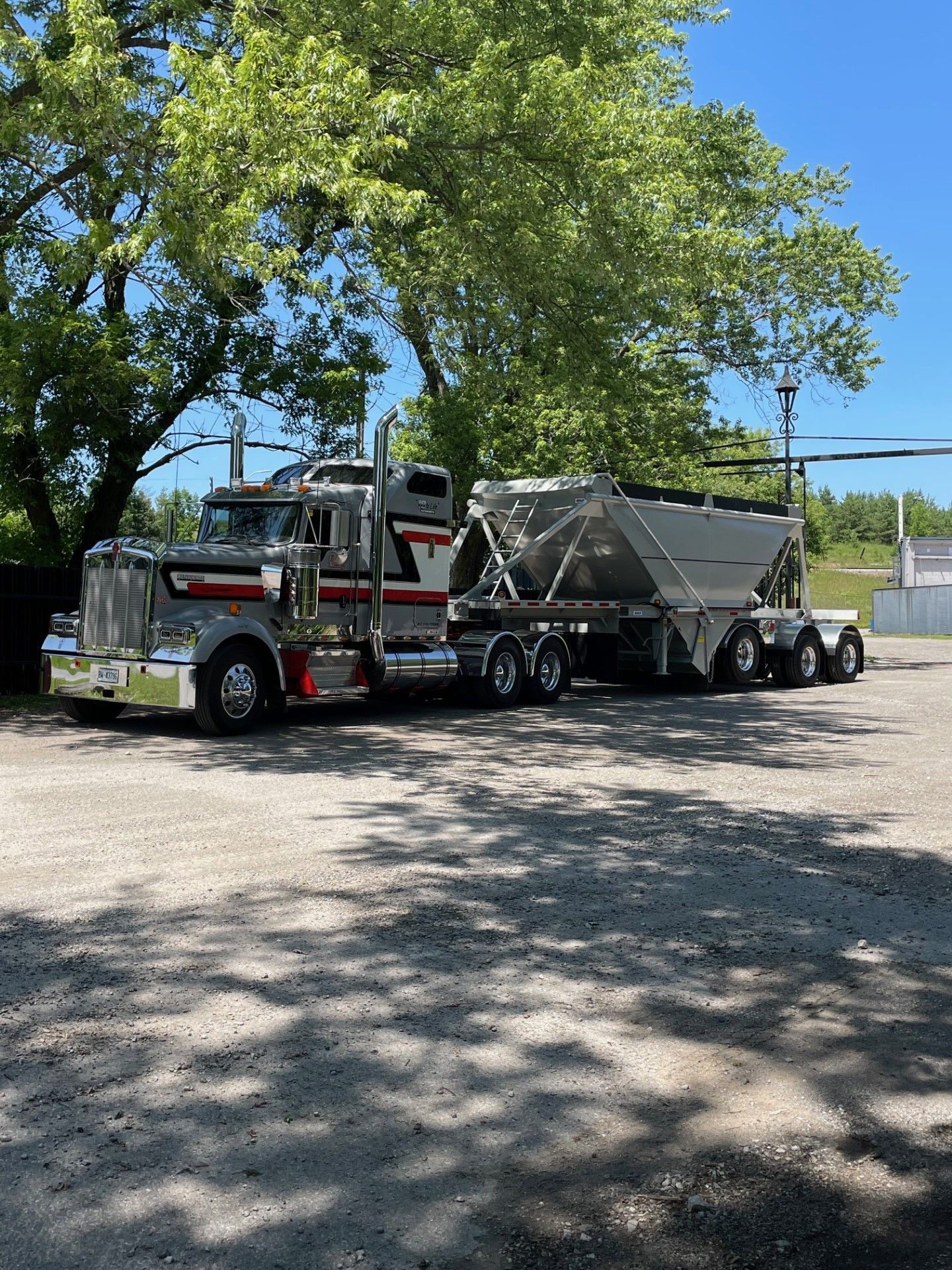 A dump truck is driving down a dirt road.