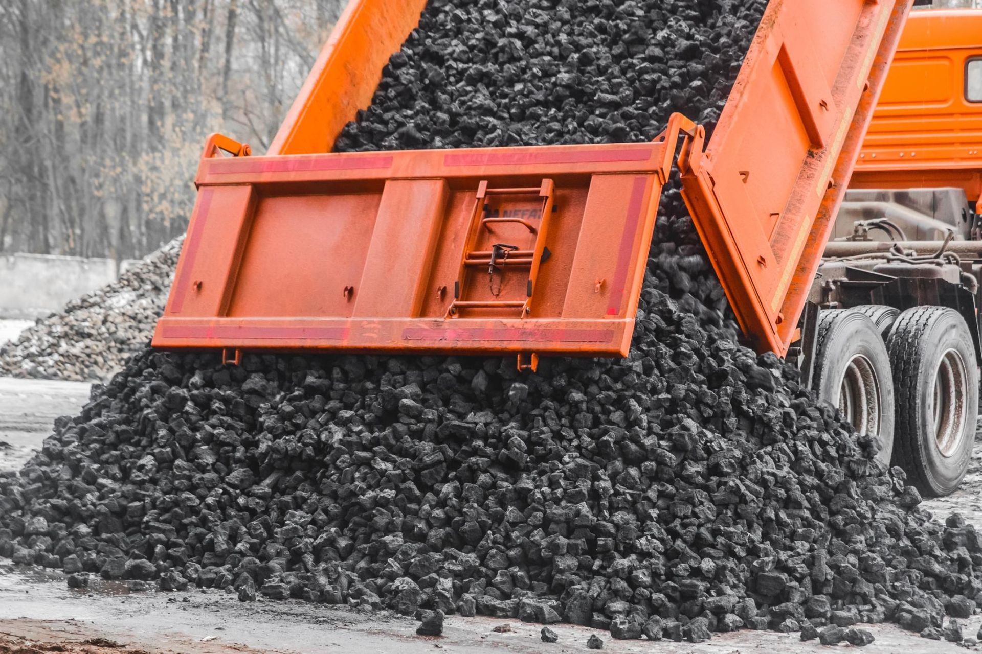 A dump truck is carrying a large pile of coal.