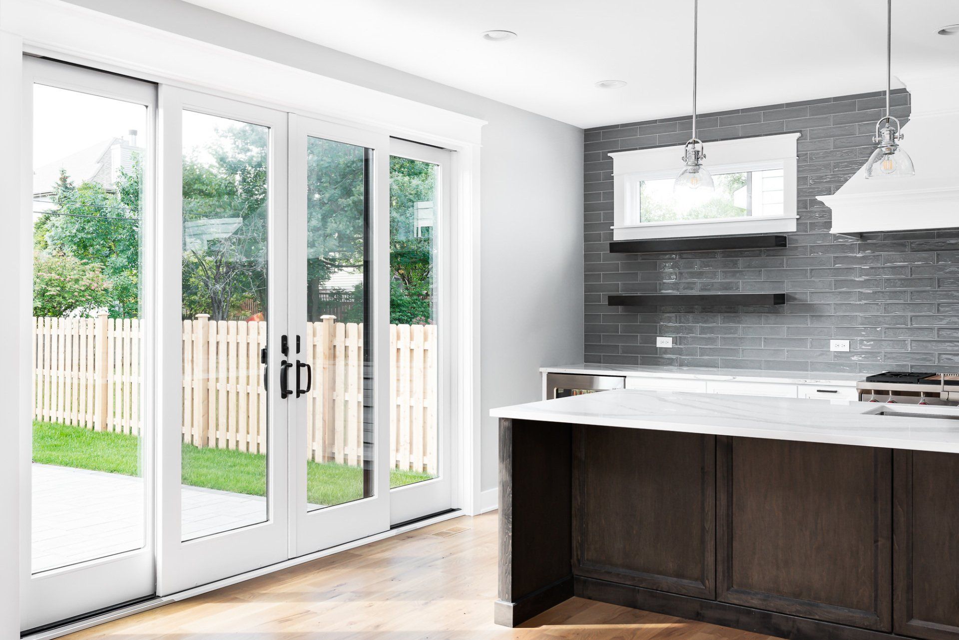 A kitchen with sliding glass doors leading to a backyard.