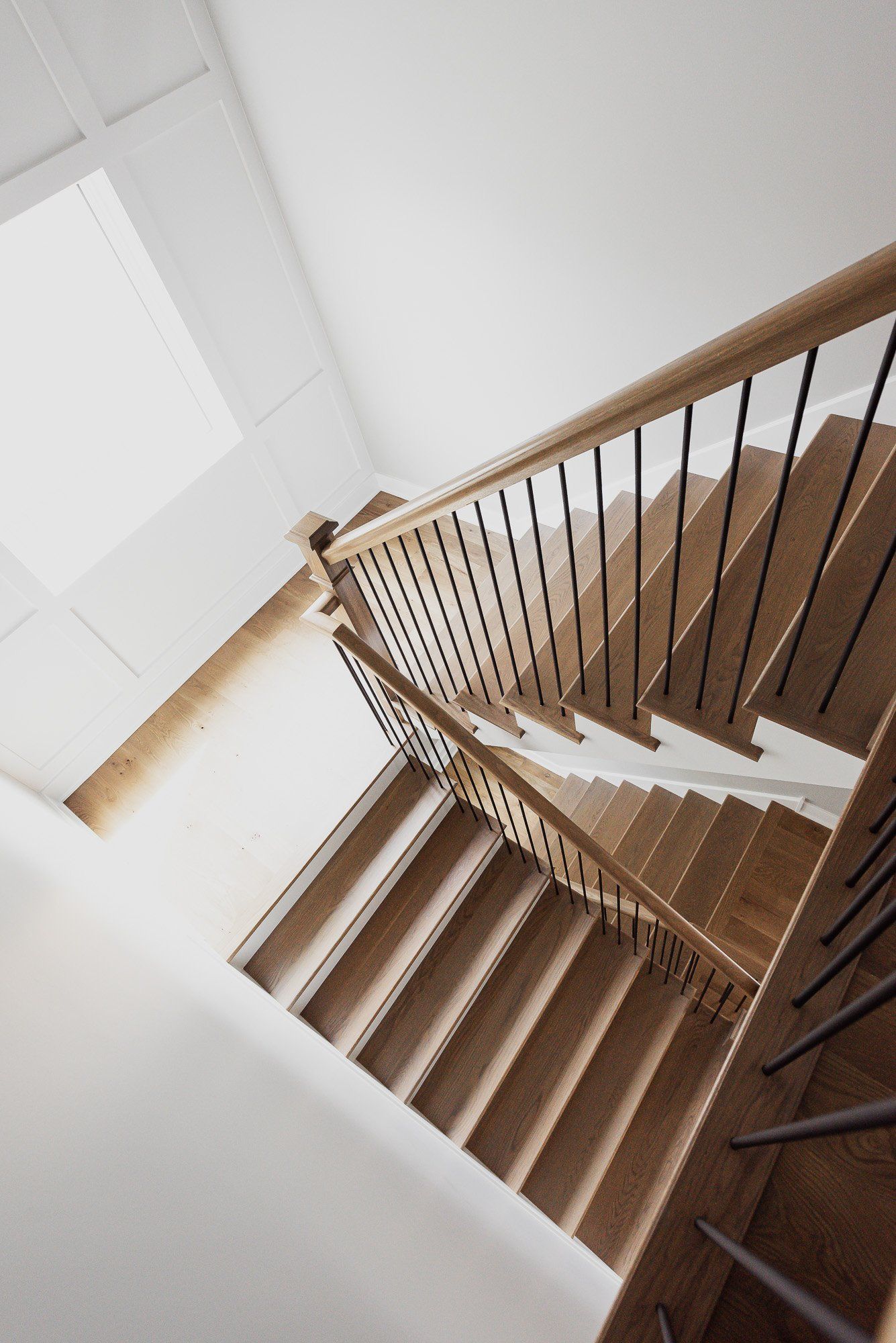 Looking up at a wooden staircase with a metal railing