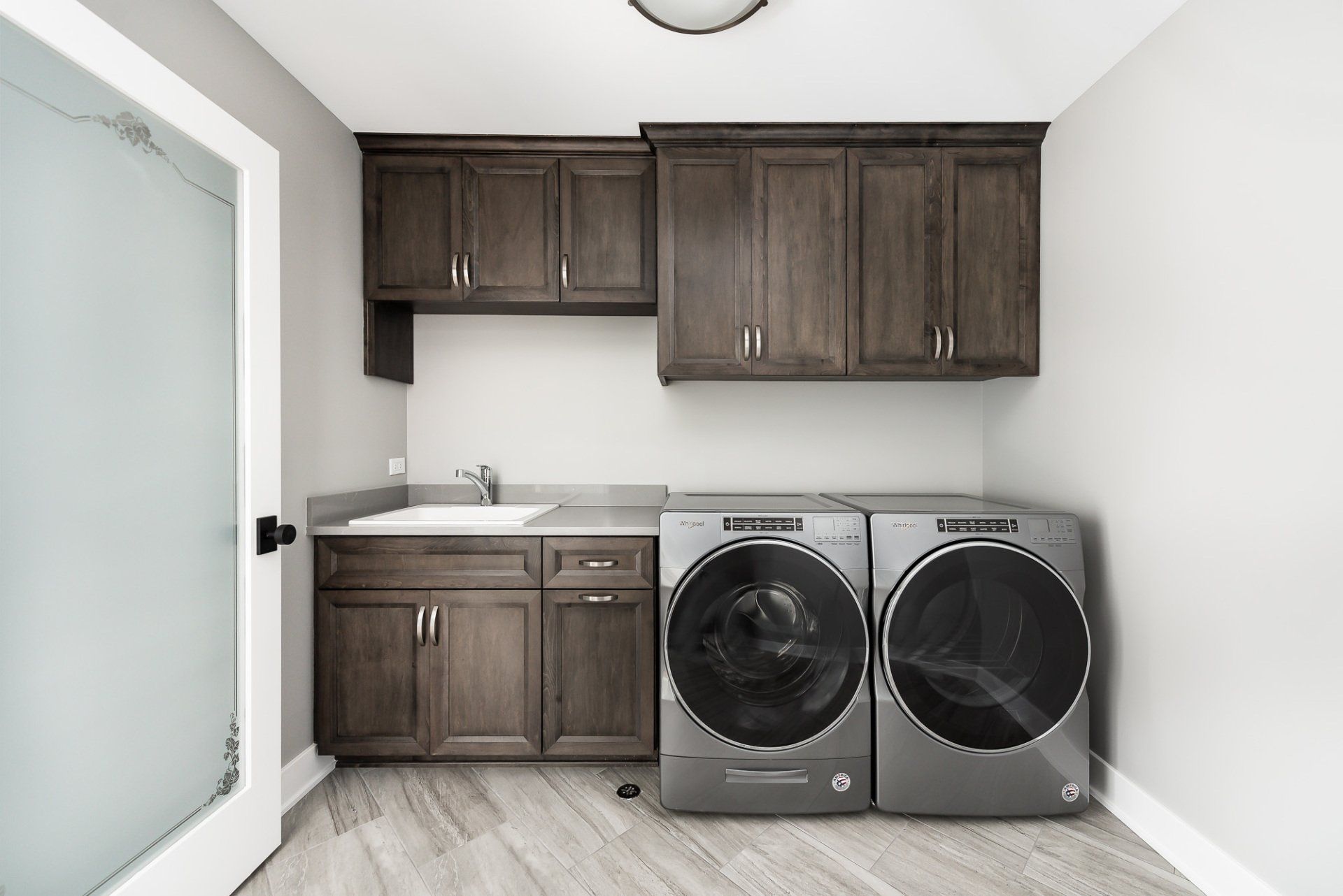 A laundry room with a washer and dryer and a sink.