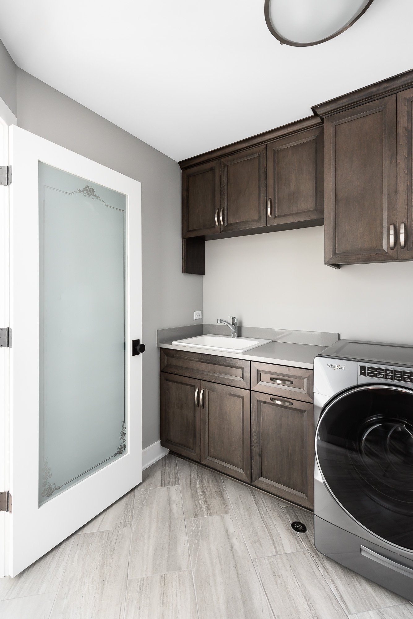 A laundry room with a washer and dryer and a sink.