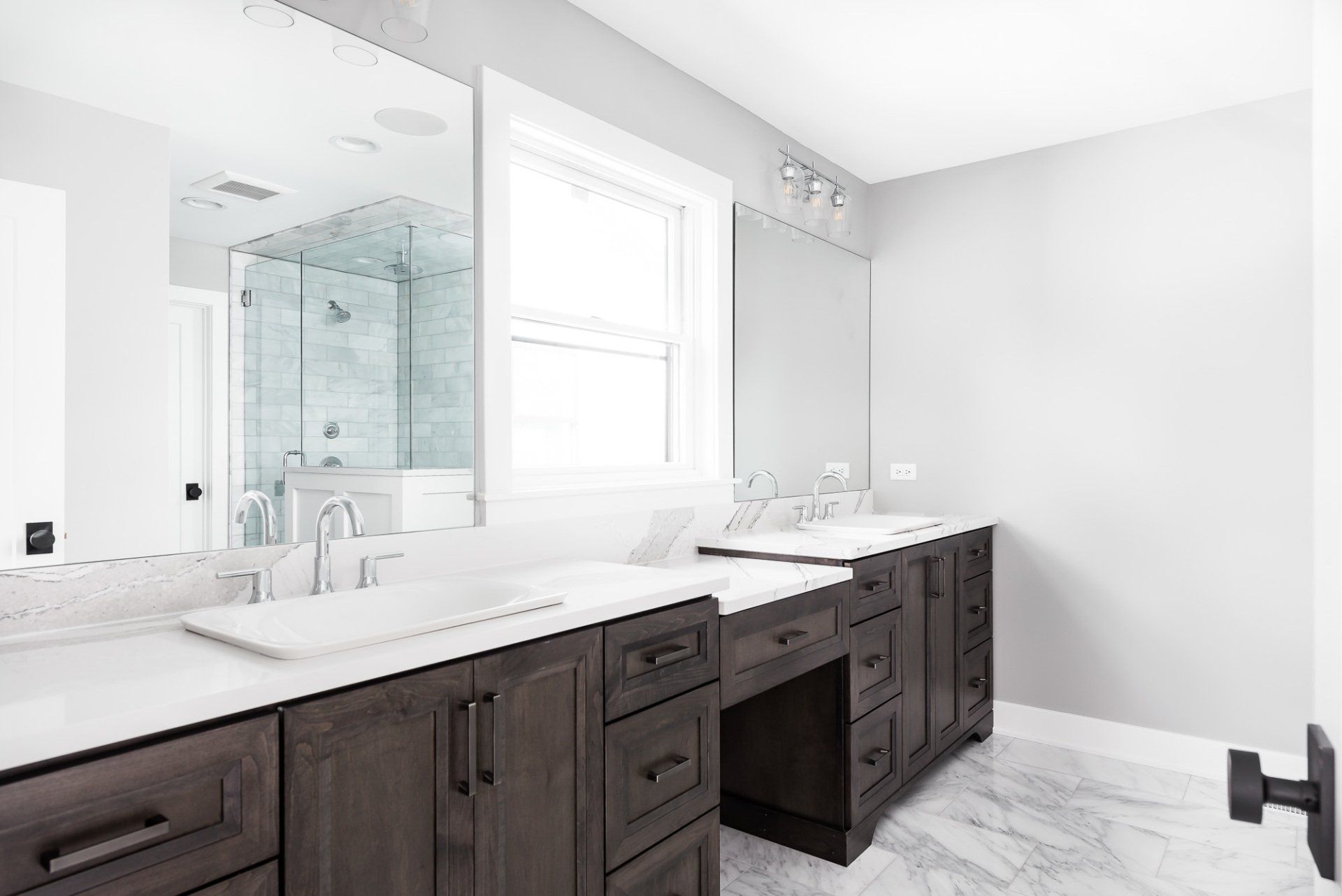 A bathroom with two sinks and a large mirror.