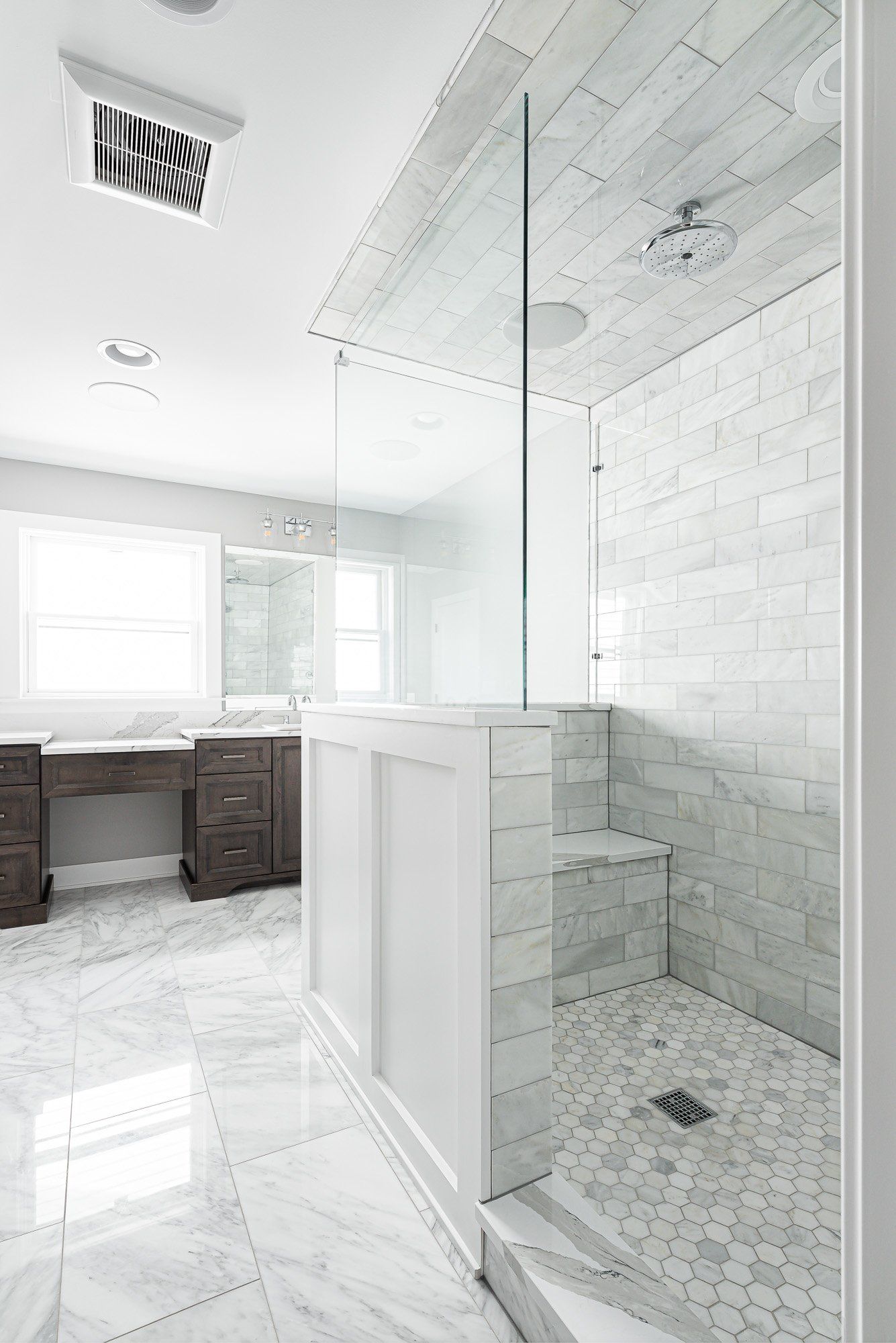 A bathroom with a walk in shower and a marble floor.