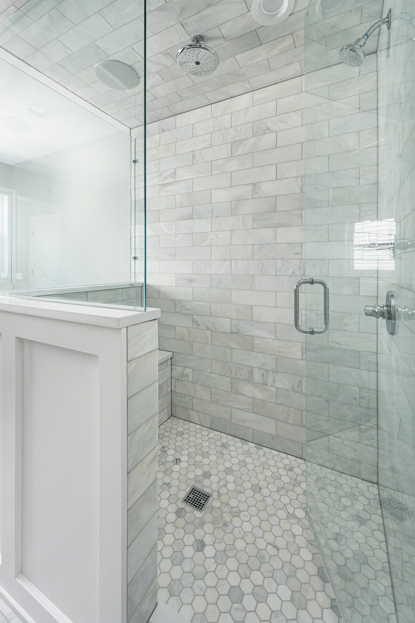 A bathroom with a walk in shower with a glass door.