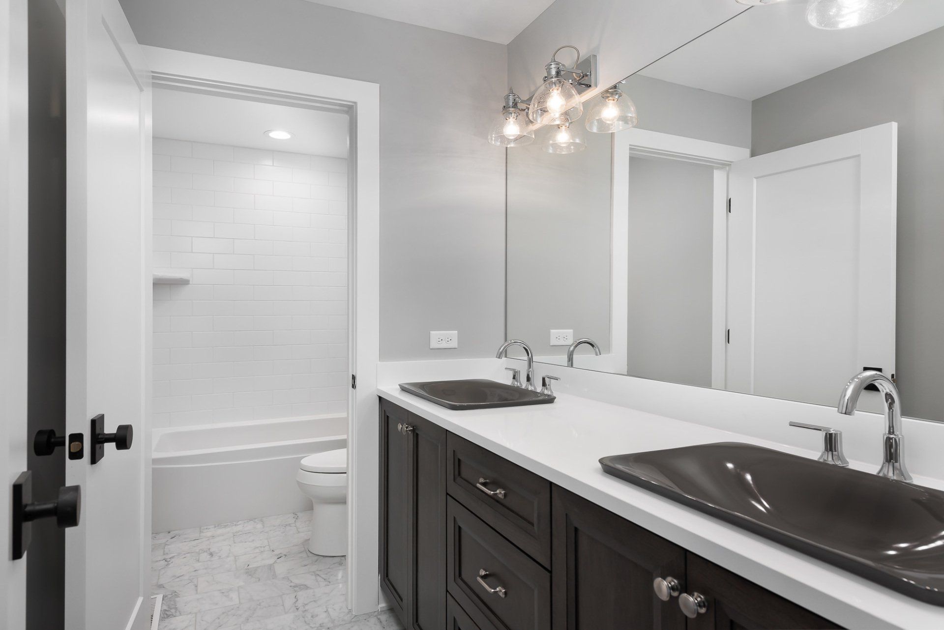 A bathroom with two sinks and a large mirror.
