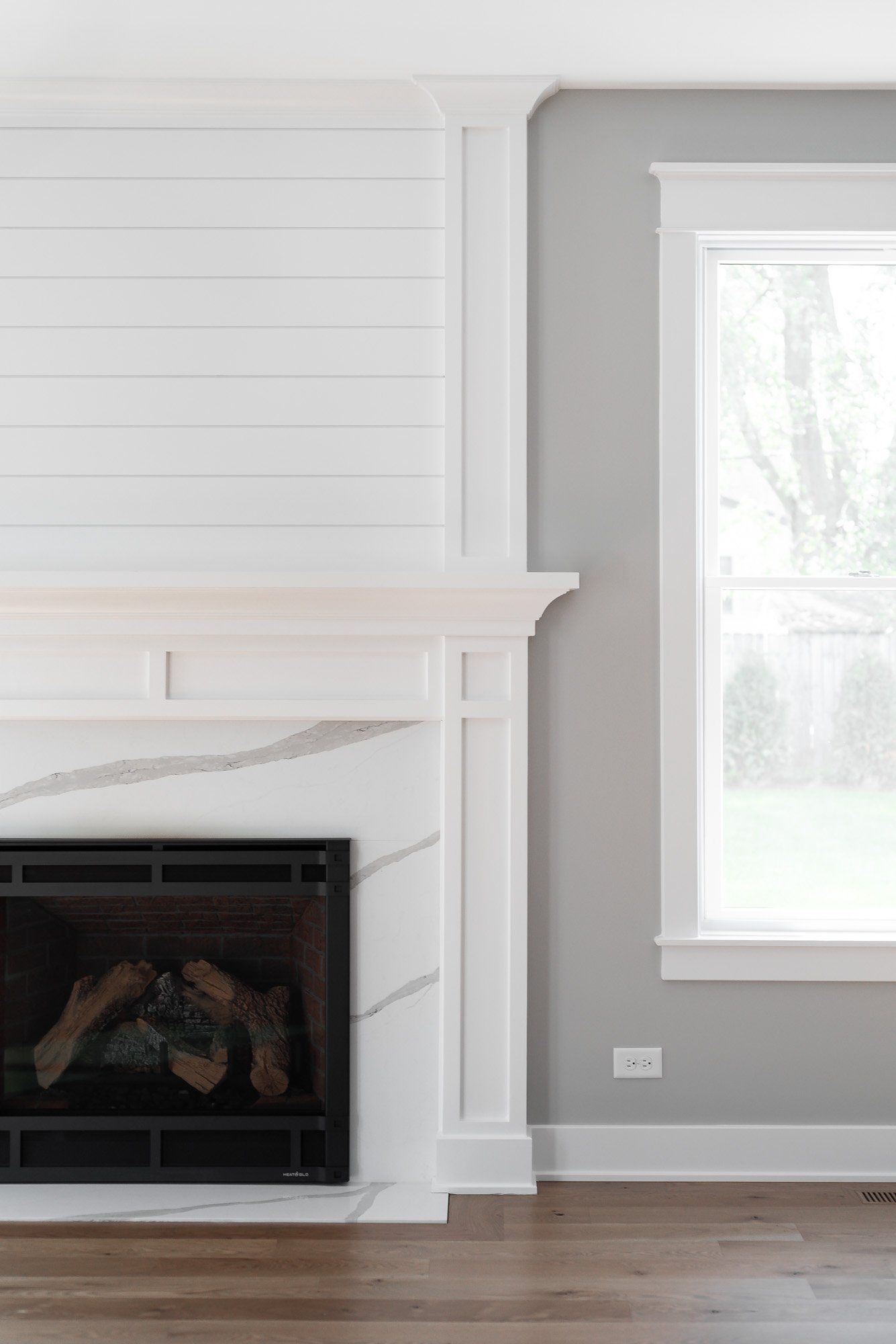 A living room with a fireplace and a window.