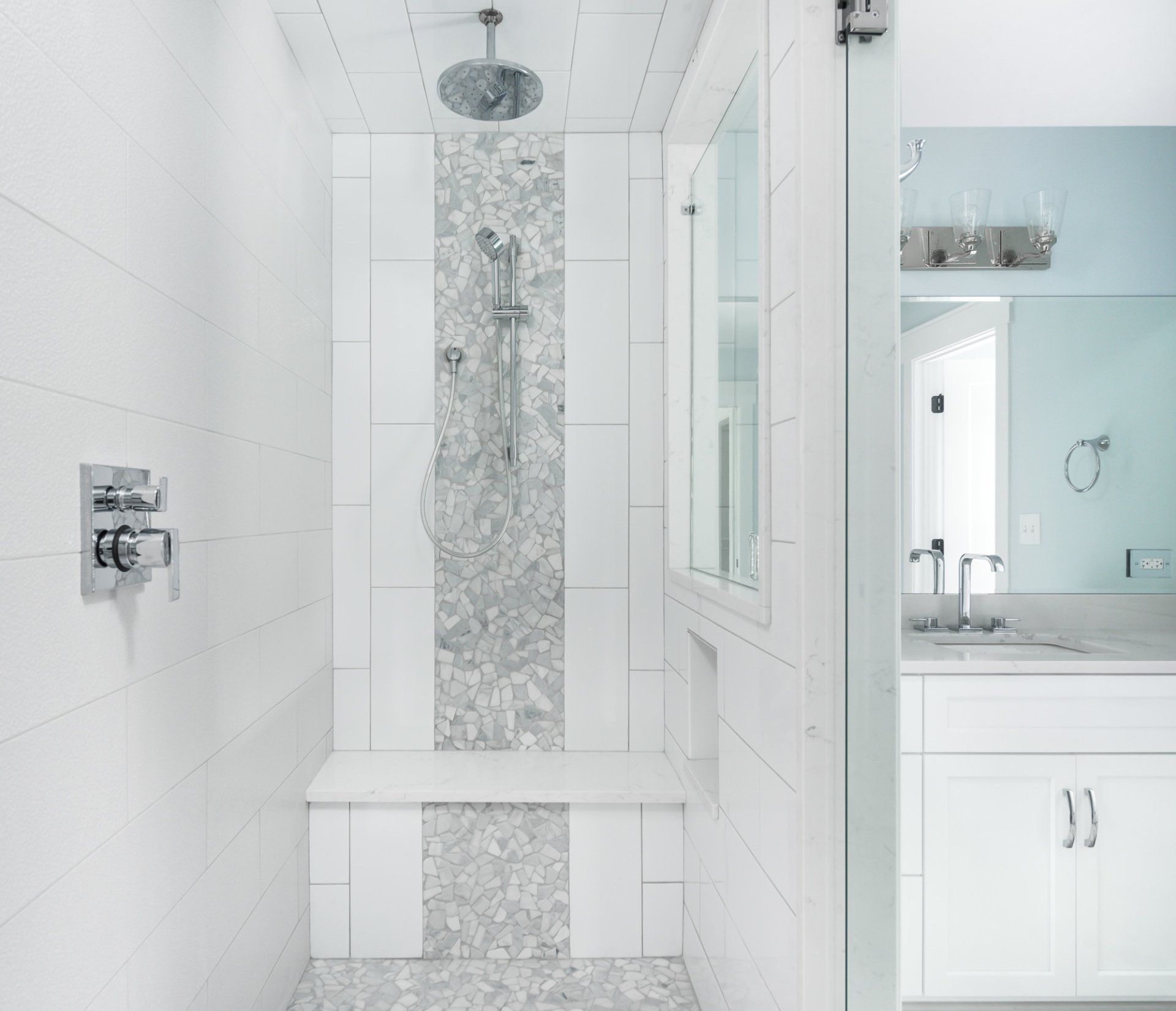 A bathroom with a walk in shower and a sink.