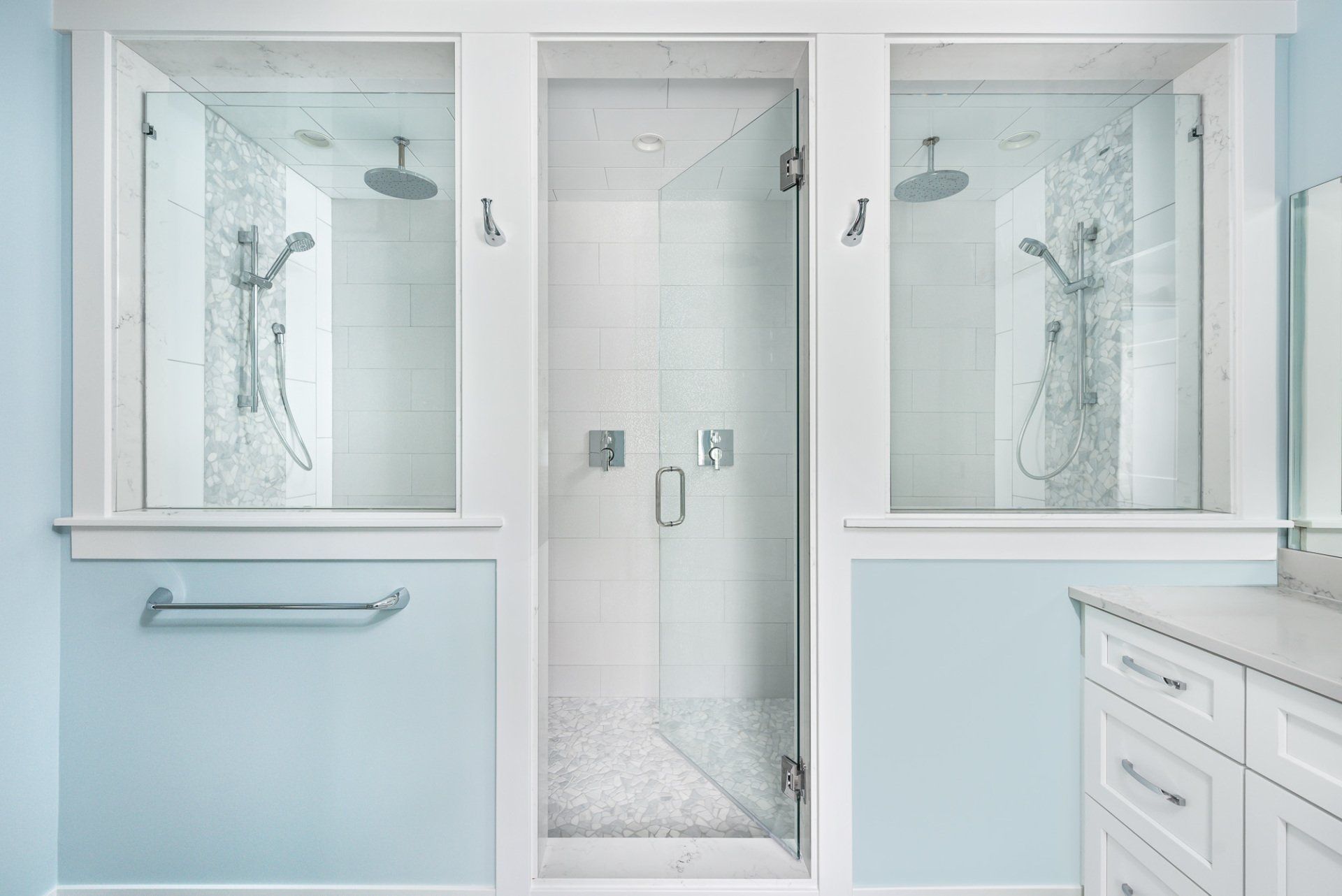 A bathroom with two showers and two windows.