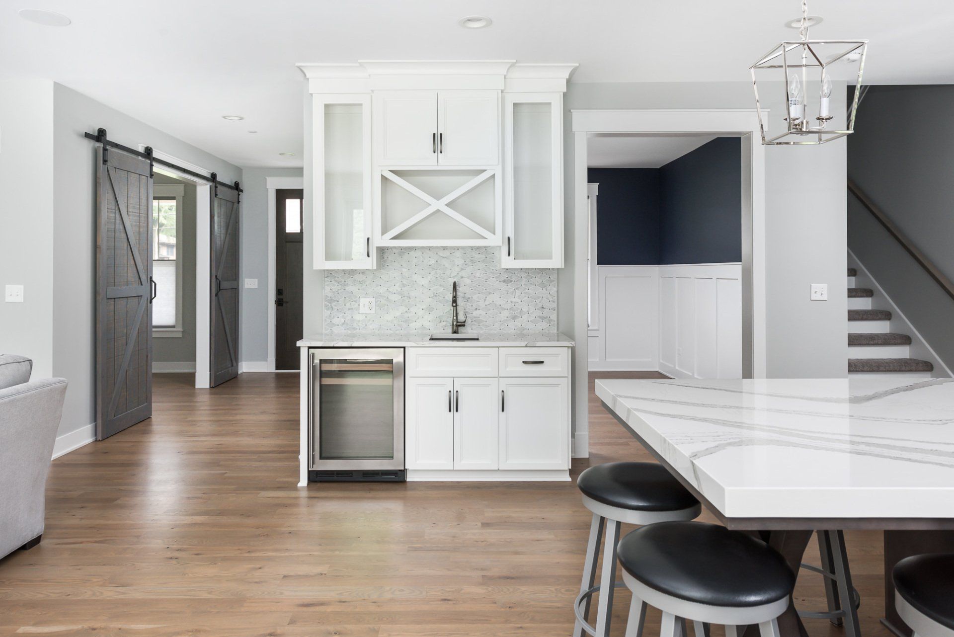 A kitchen with white cabinets and a marble counter top.