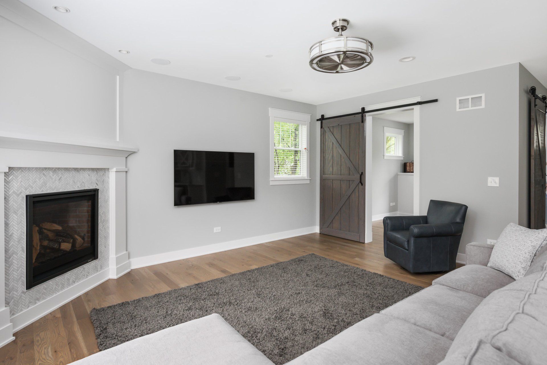 A living room with a couch , chair , fireplace and television.