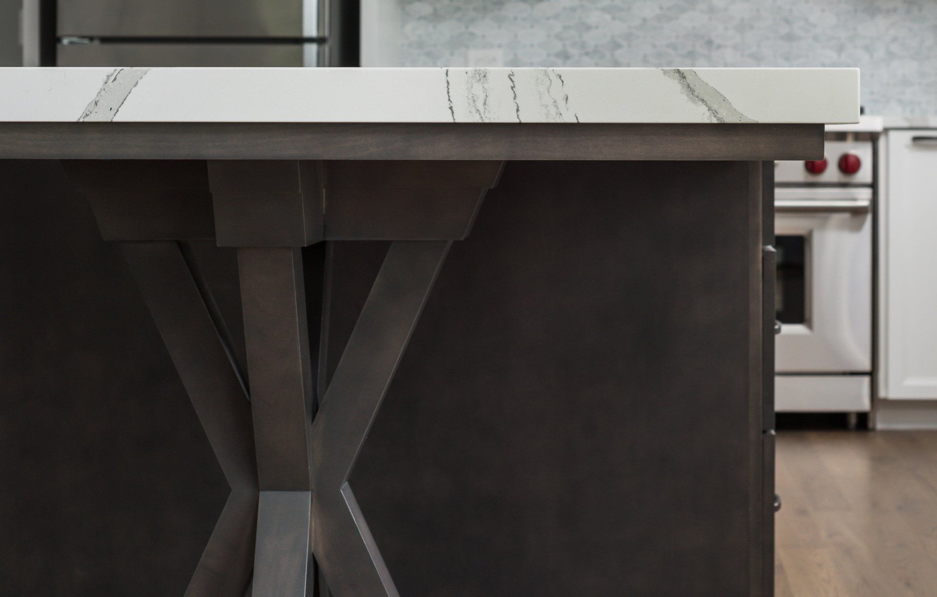 A kitchen with a white counter top and a black island.