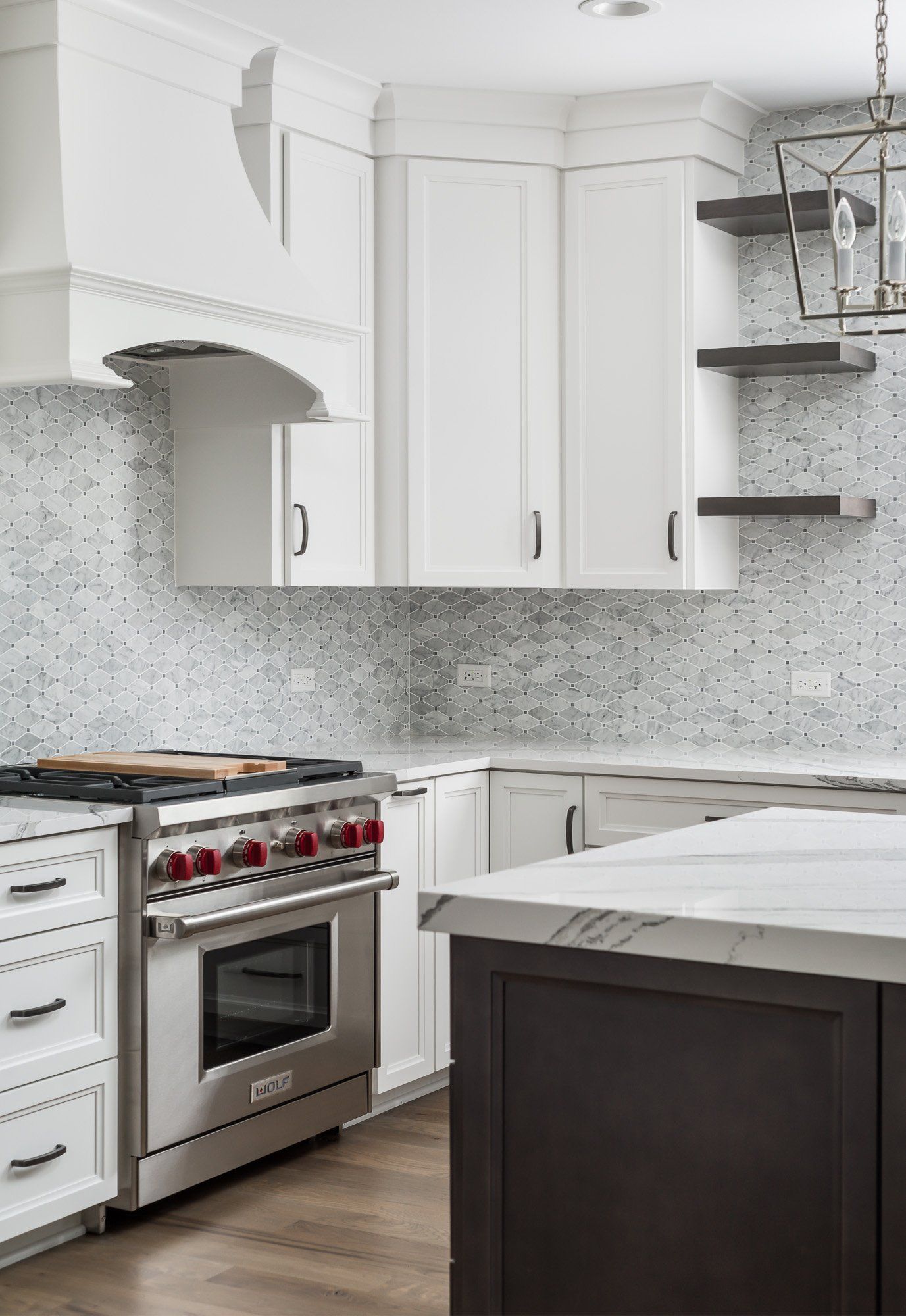 A kitchen with white cabinets , stainless steel appliances , and a large island.