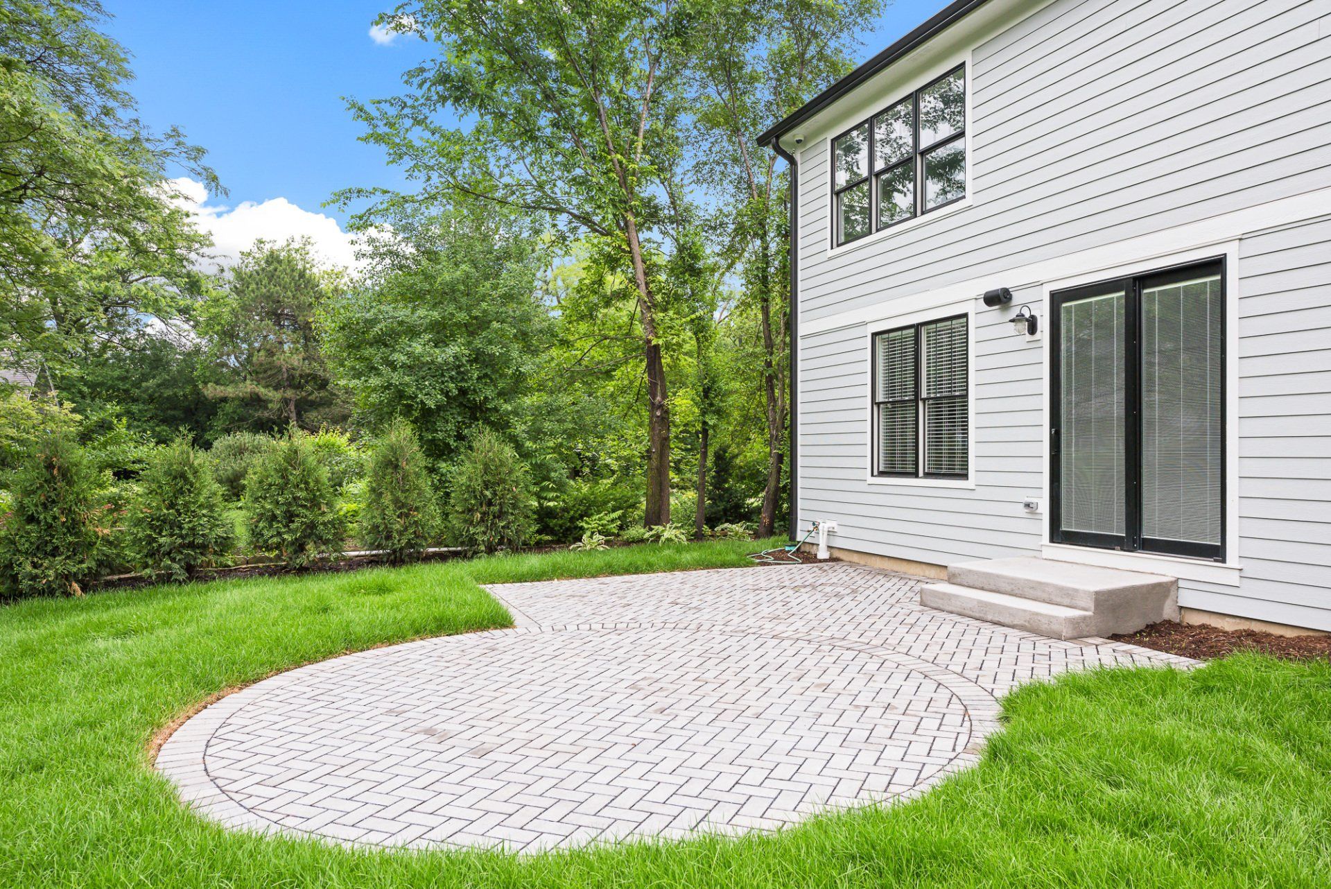 A white house with a circular patio in front of it.