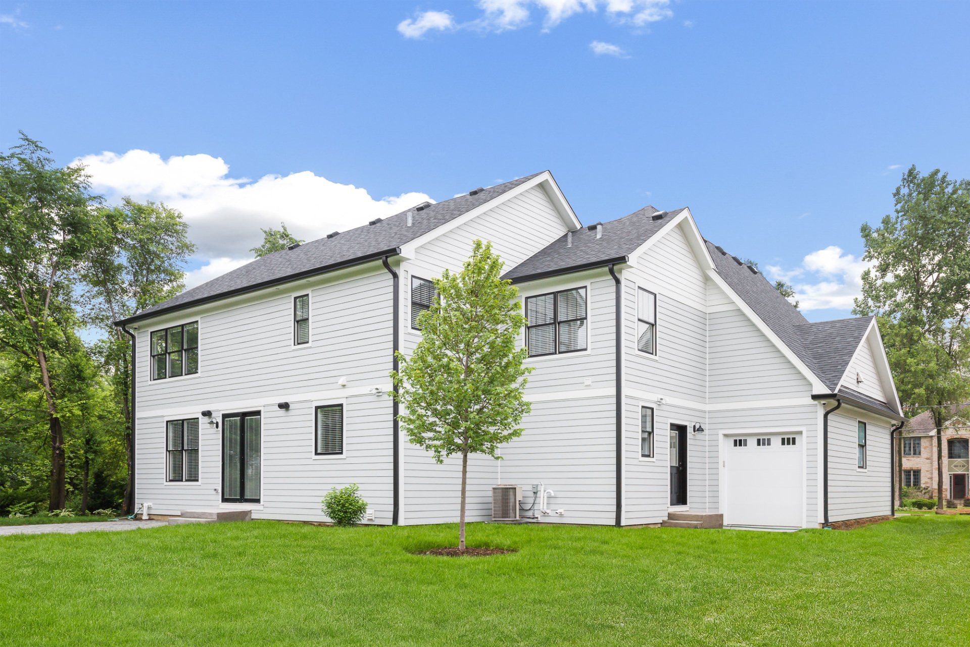 A large white house with a lush green lawn in front of it.