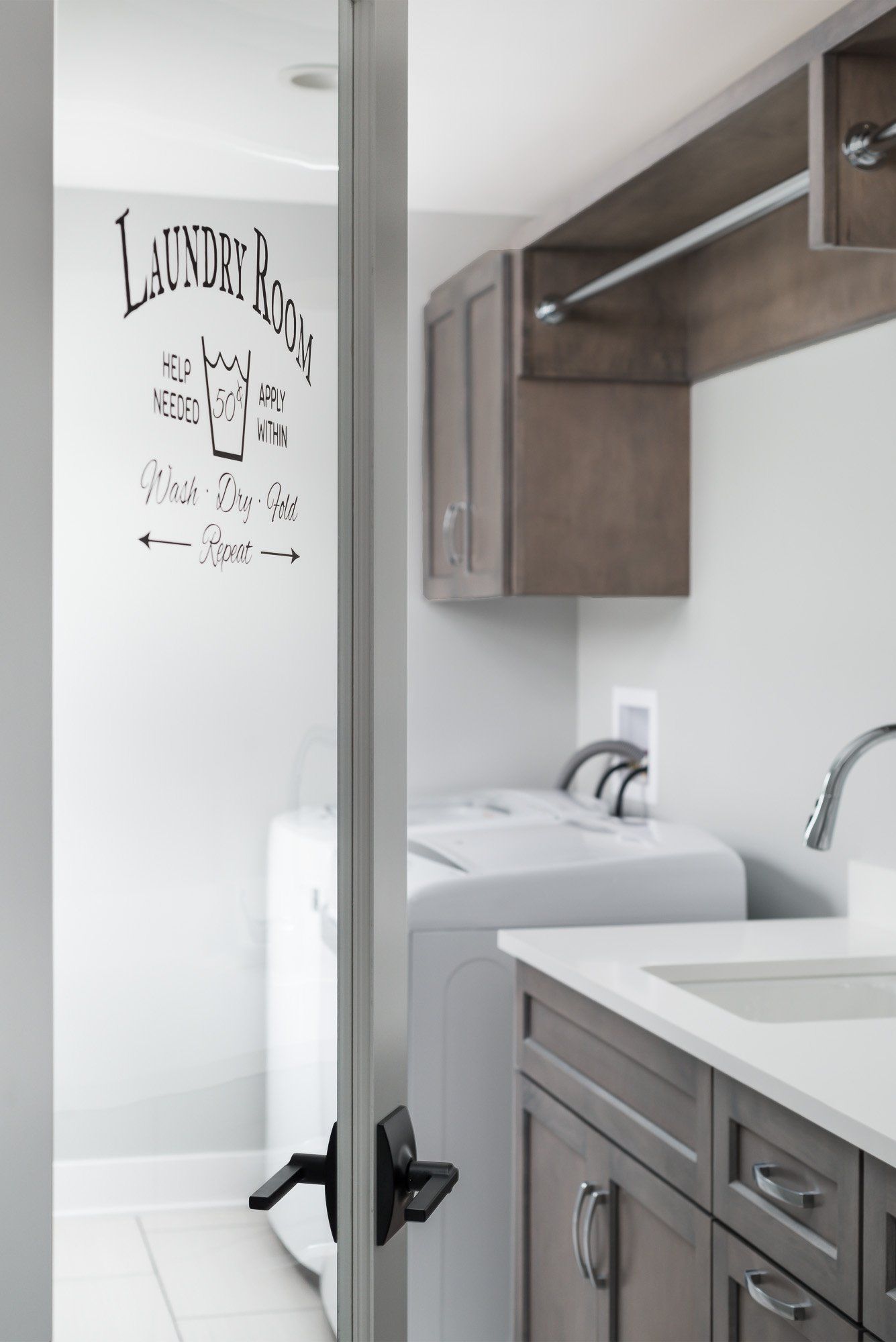 A laundry room with a washer and dryer and a sink