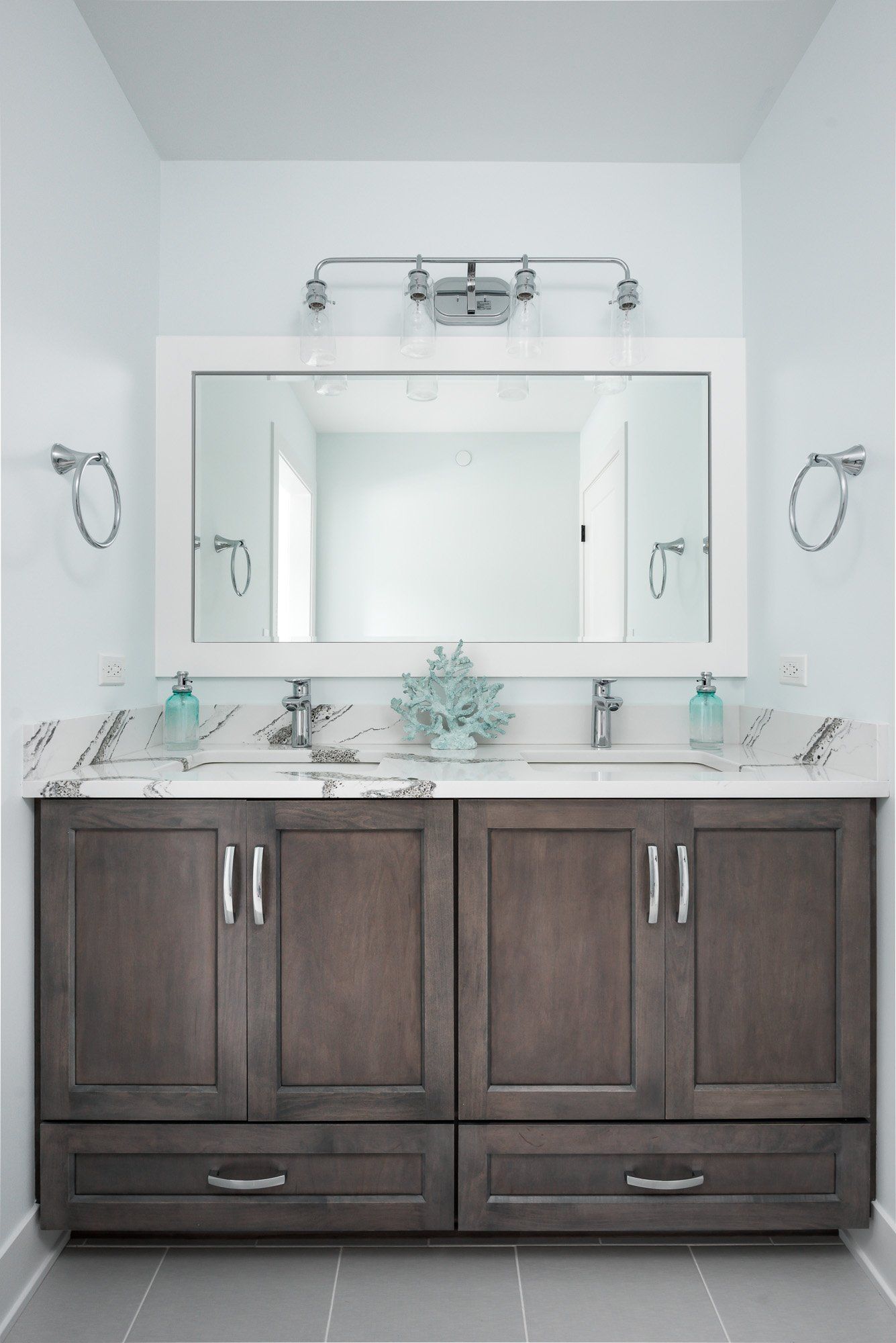 A bathroom with two sinks and a large mirror.
