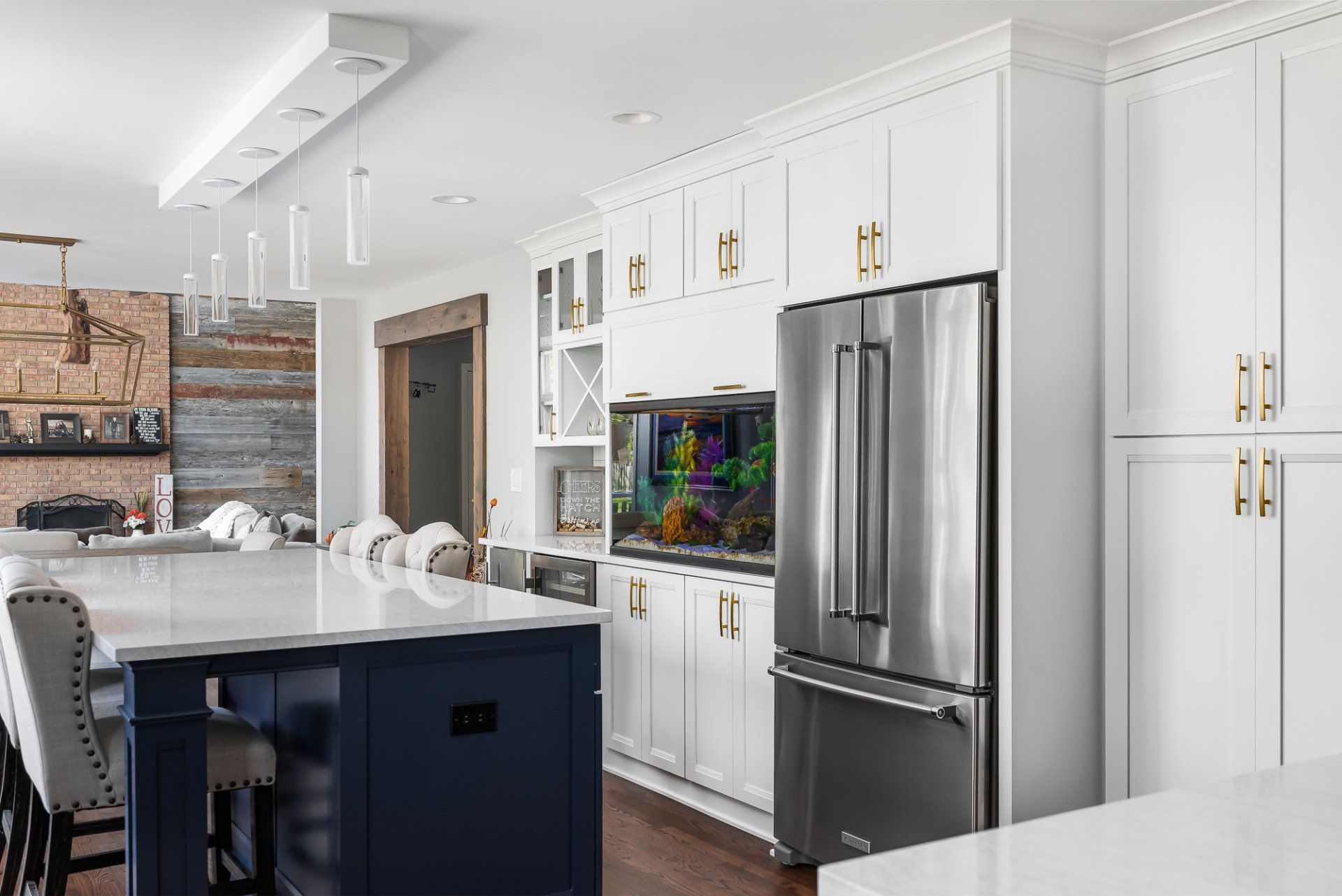 A kitchen with white cabinets , stainless steel appliances , and a large island.