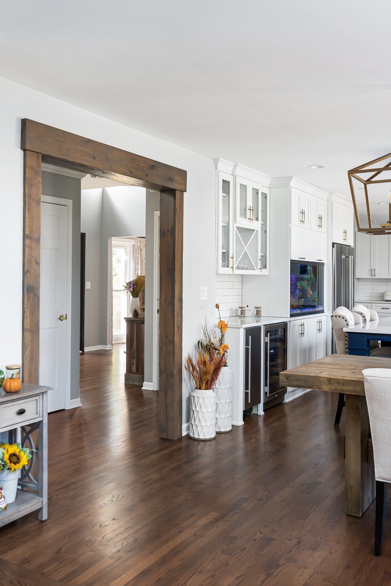 A living room with hardwood floors , white cabinets , a table and chairs.