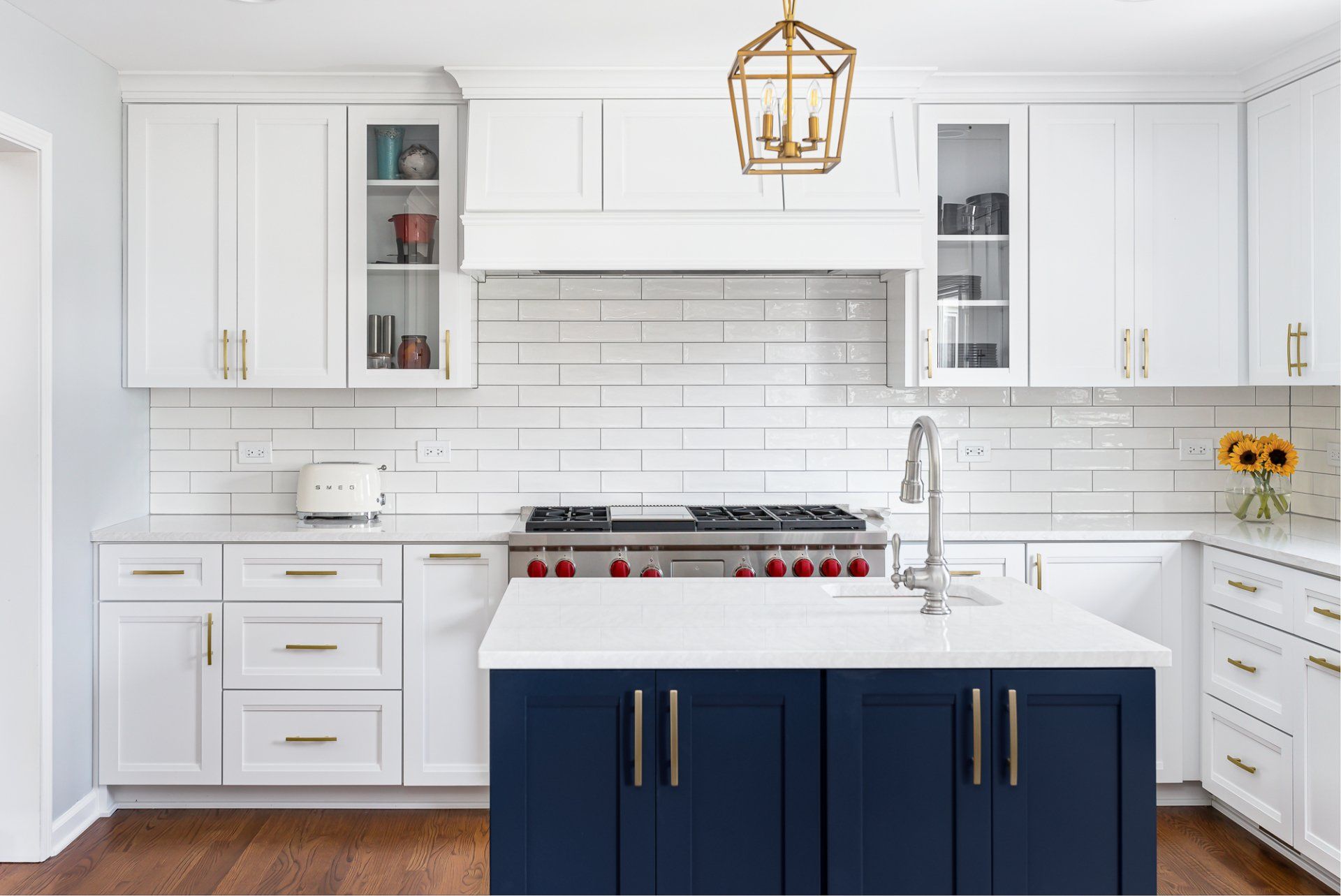 A kitchen with white cabinets and blue cabinets and a large island.