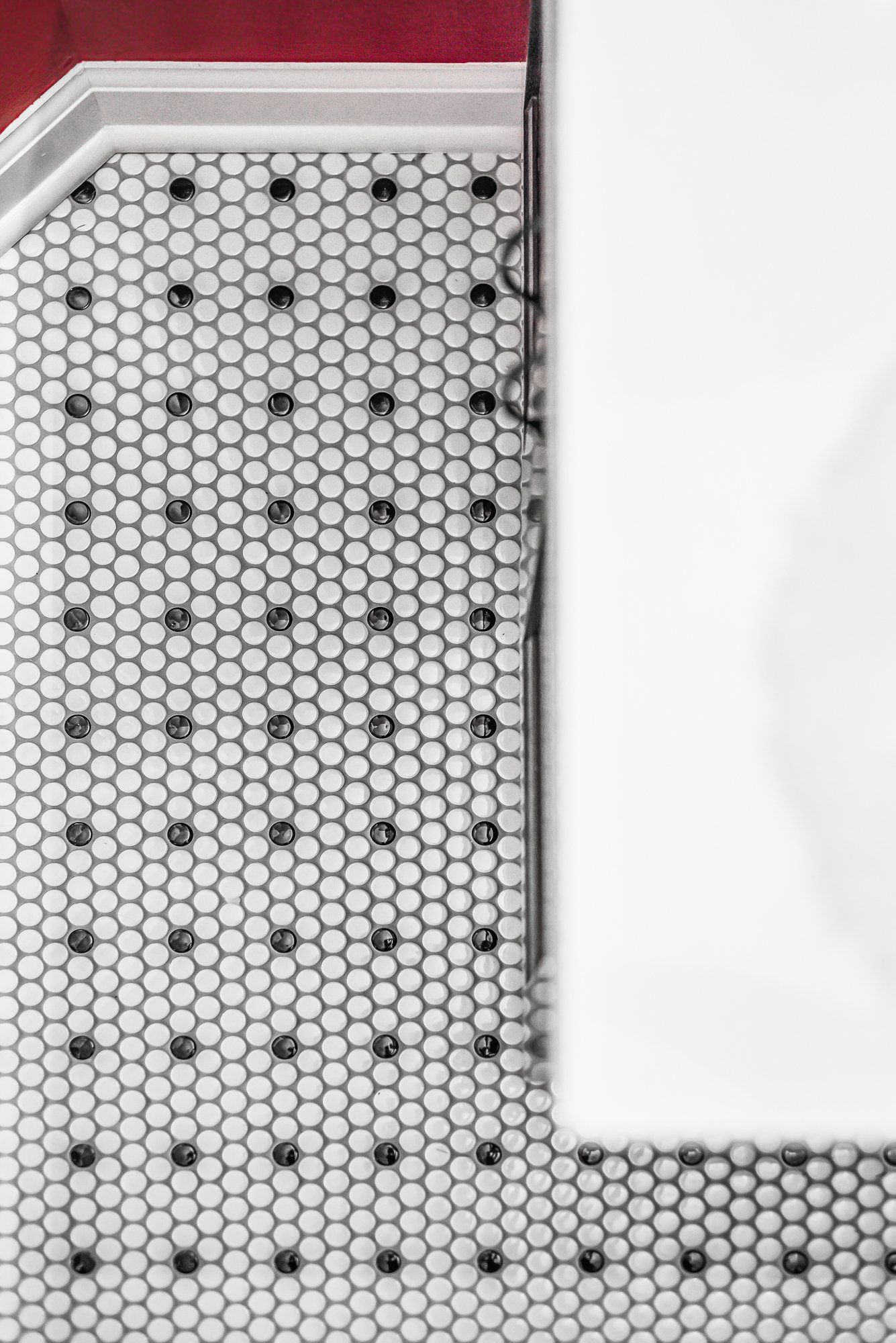 A bathroom with a black and white tile floor and a bathtub.