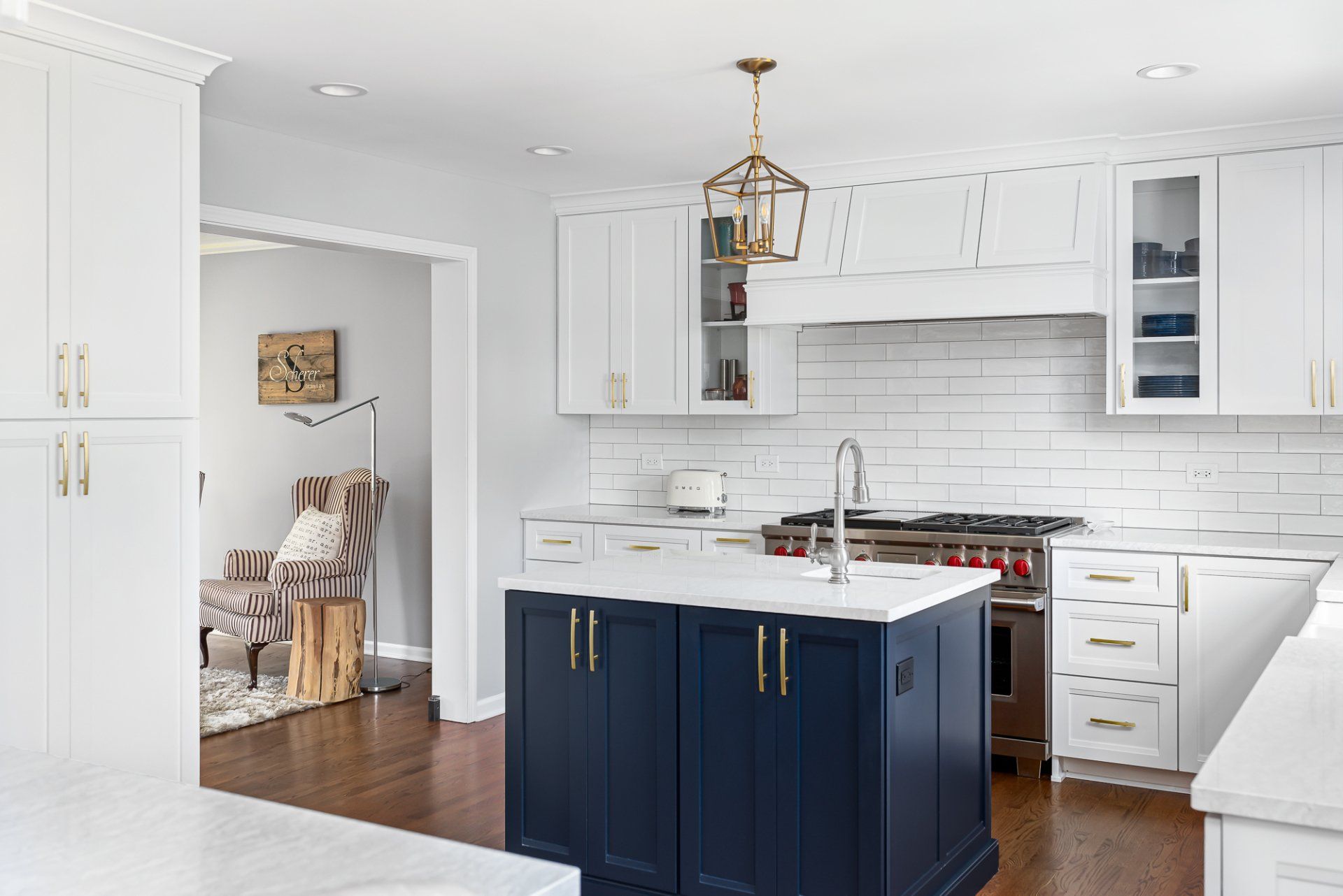 A kitchen with white cabinets and a blue island in the middle.