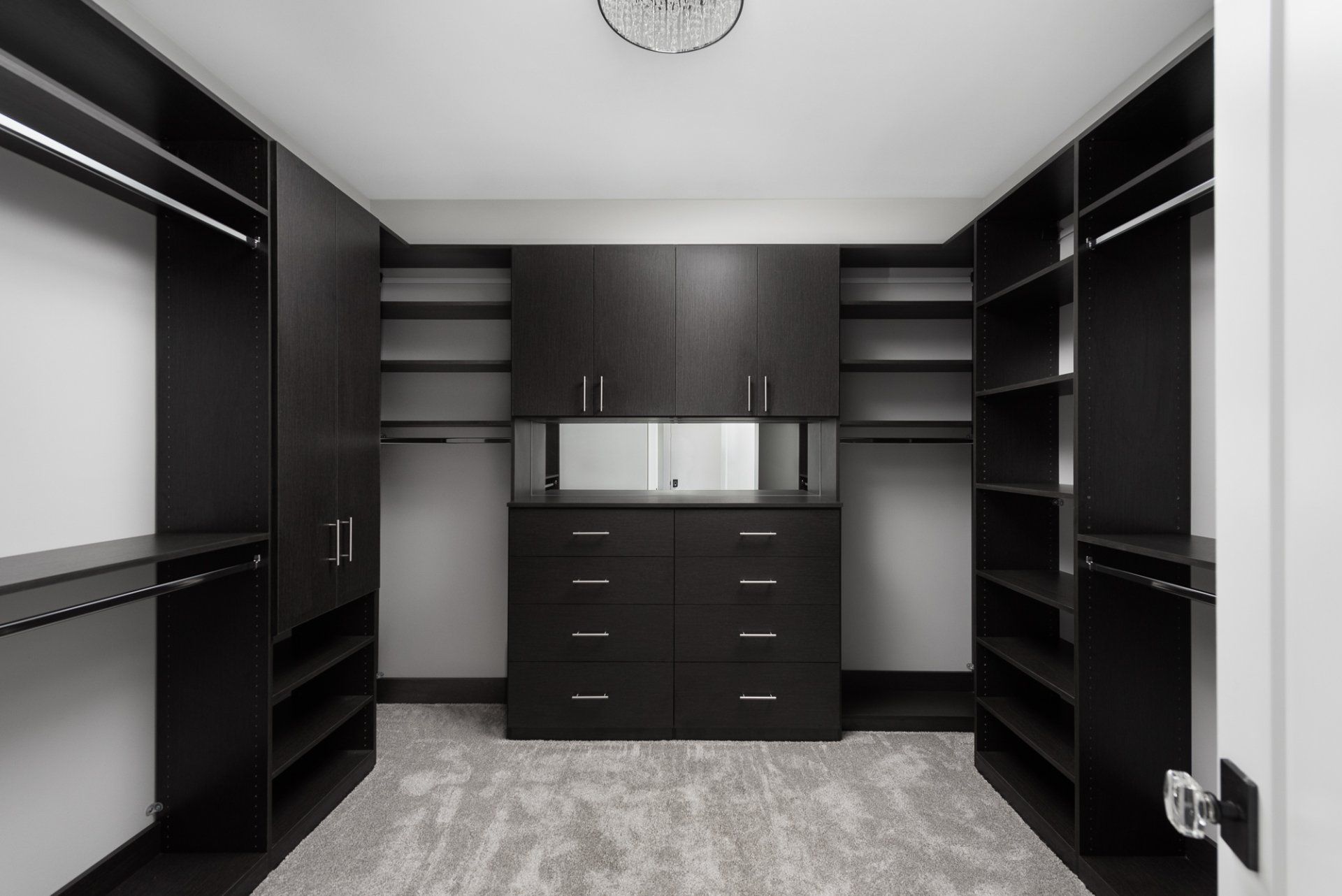 A walk in closet with lots of shelves and drawers