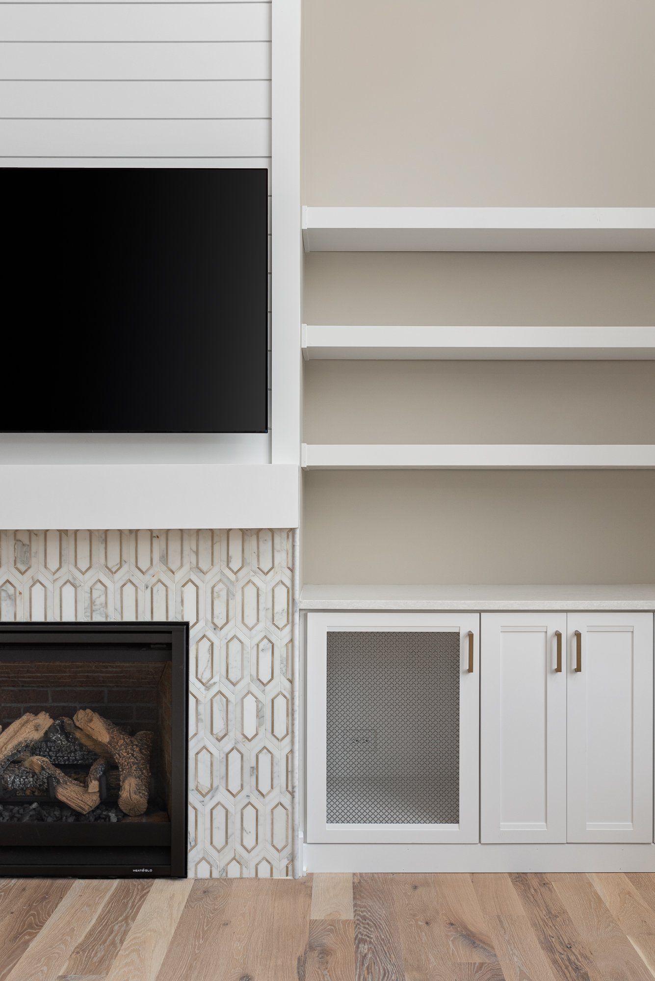 A living room with a fireplace , shelves , and a flat screen tv.