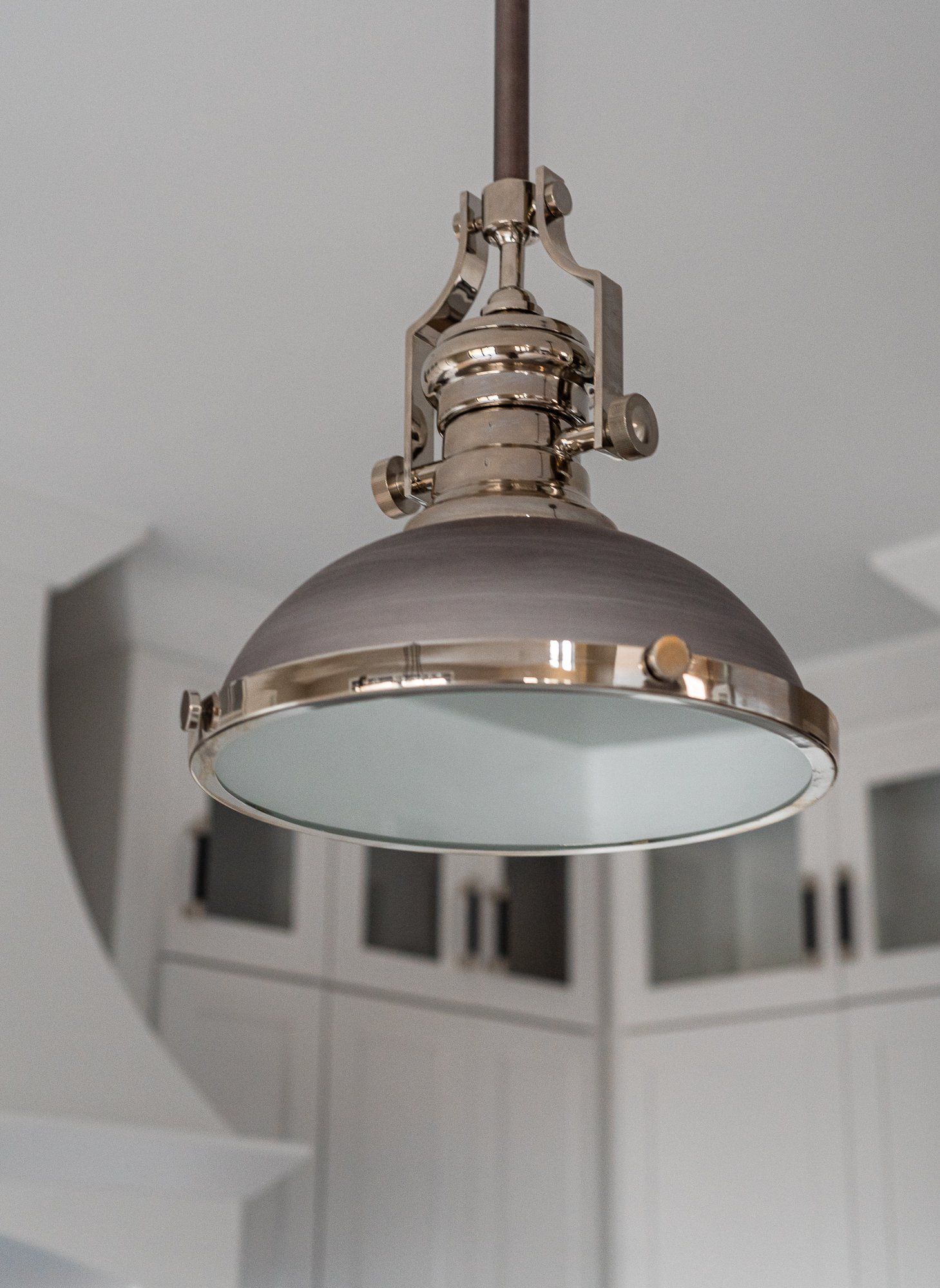 A pendant light is hanging from the ceiling in a kitchen.